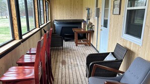 Una terraza de madera con asientos, un jacuzzi y una puerta con el rótulo "The Lodge".