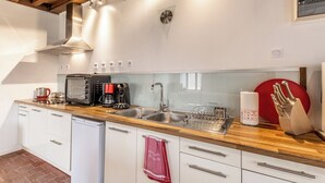 A modern kitchen with a wooden countertop, stainless steel appliances, and a red towel hanging on the door. - Le Tilleul - CHISSEY-EN-MORVAN (CHISSEY-EN-MORVAN)