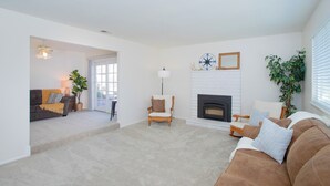 Una sala de estar con chimenea, un sofá, un sillón y una lámpara.