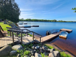 A wooden dock extending into a calm lake with boats docked.