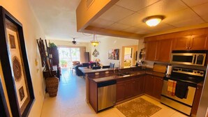 A spacious kitchen with a central island, stainless steel appliances, and wooden cabinets.