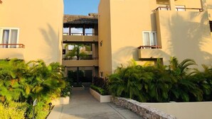Un resort con edificios de dos pisos, un patio central y jardines tropicales.