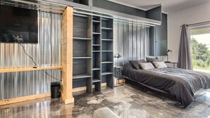 Une chambre moderne dotée d’un grand lit, d’étagères intégrées et offrant une vue sur l’extérieur.