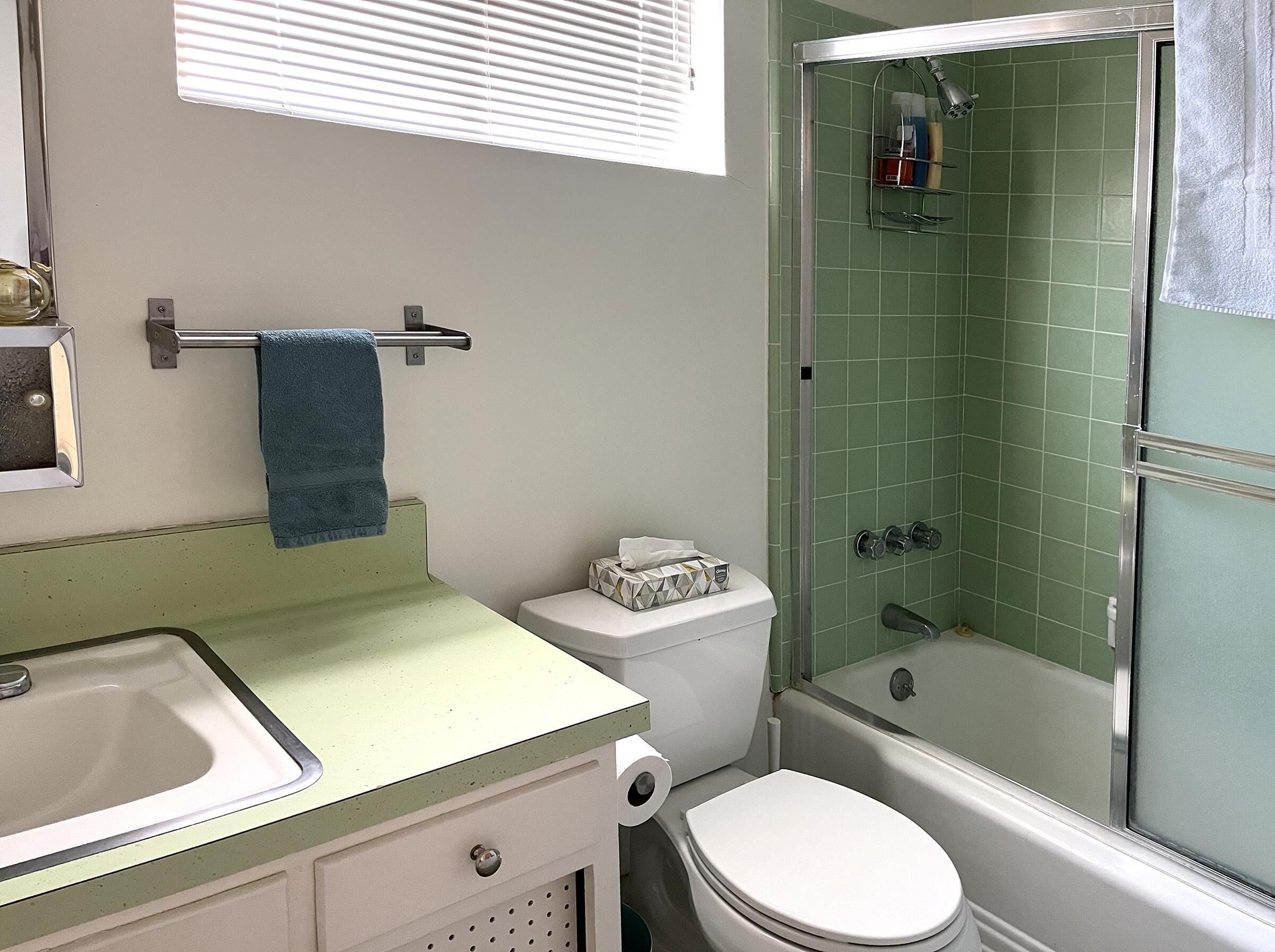 Een badkamer met toilet, wastafel en douche.
