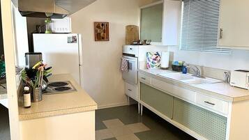 Een bad/douchecombinatie, een haardroger, handdoeken, zeep