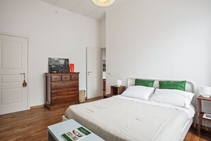 A bedroom with a bed, a dresser, a nightstand, and a door. - Appartamento Di Stile Al Conservatorio (Palermo)