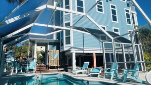 Une maison à deux étages dotée d’une piscine, d’un espace extérieur aménagé et d’un patio couvert.