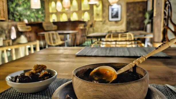 Un espace repas avec une table en bois, des bols remplis de nourriture et une cuillère.