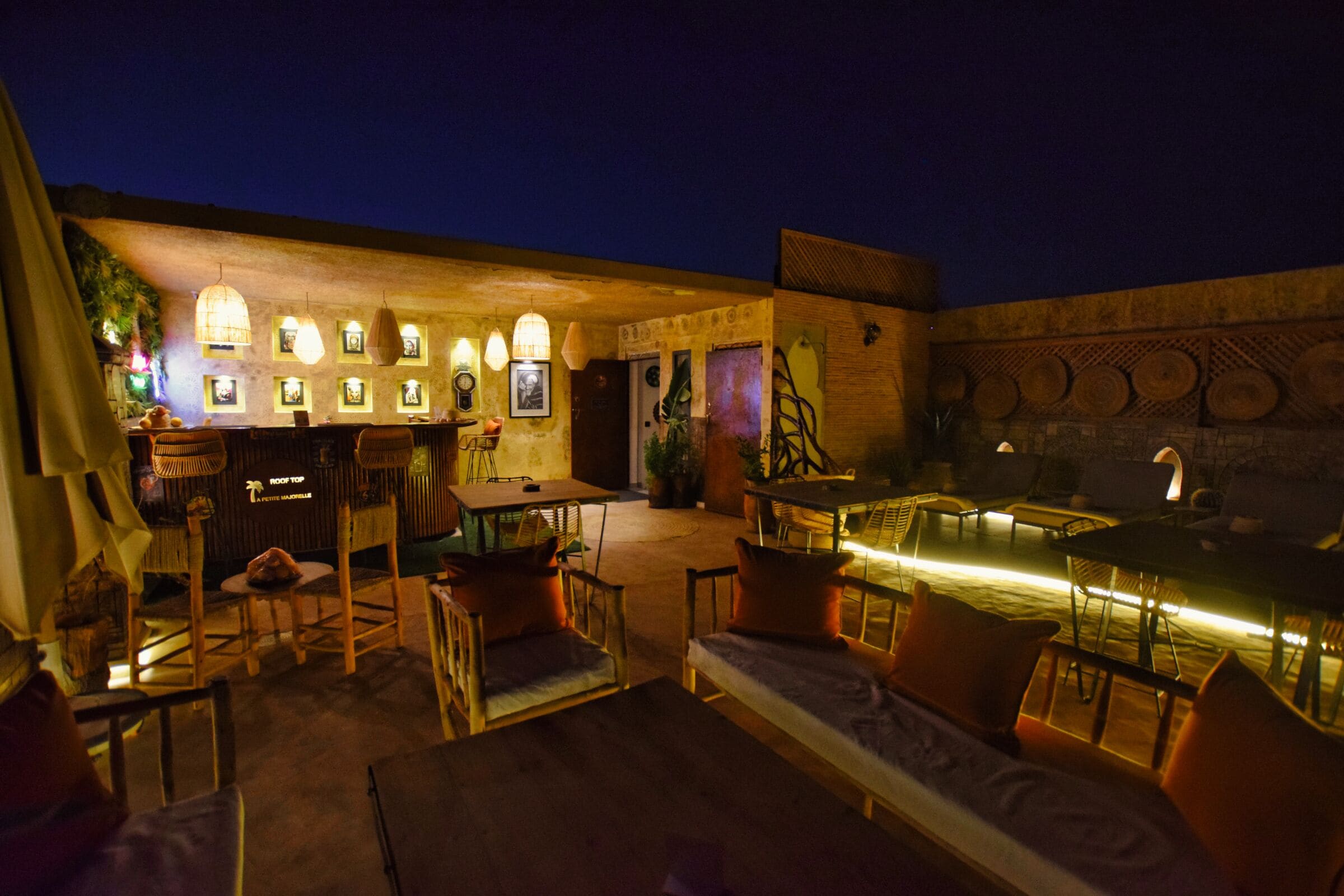 Een terras met tafels en stoelen, een bar en een decoratieve muur.