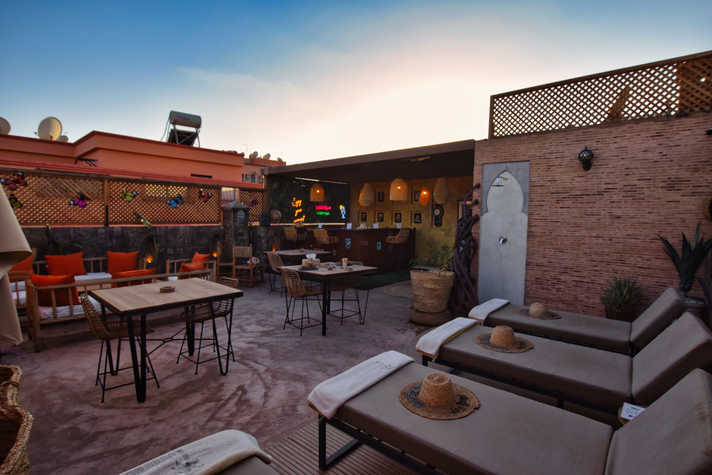 An outdoor patio area with seating arrangements, a bar, and a brick wall.