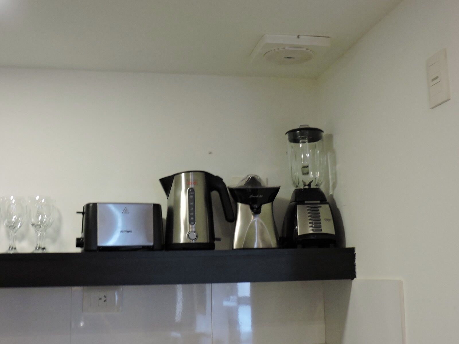 Una encimera de cocina con cafetera, licuadora, hervidor y tostadora.