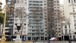 A city square with a fountain, trees, and modern buildings in the background. - Rivadavia Apartments (Buenos Aires)