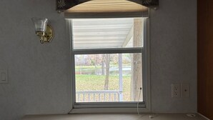 A room with a large window, a light fixture, and a power outlet. - Tranquil cabin with AC on charming Lake Sarah.   (Erskine)