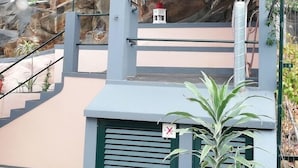 A staircase leading up to a building with a rock wall backdrop. - FX Hostel (Funchal)