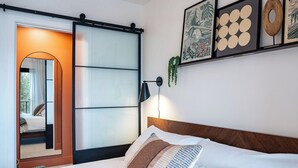 Una camera da letto con un letto, una porta scorrevole e opere d'arte appese al muro.