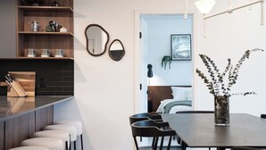 Una cucina moderna con un angolo bar, sgabelli e un tavolo da pranzo con sedie.