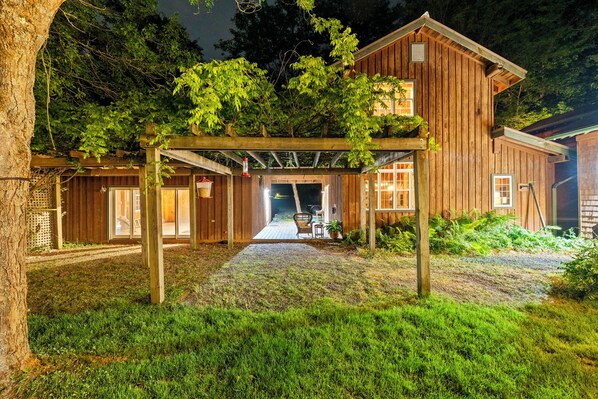 A wooden cabin with a covered porch, a visible door, and a pathway leading to the entrance.
