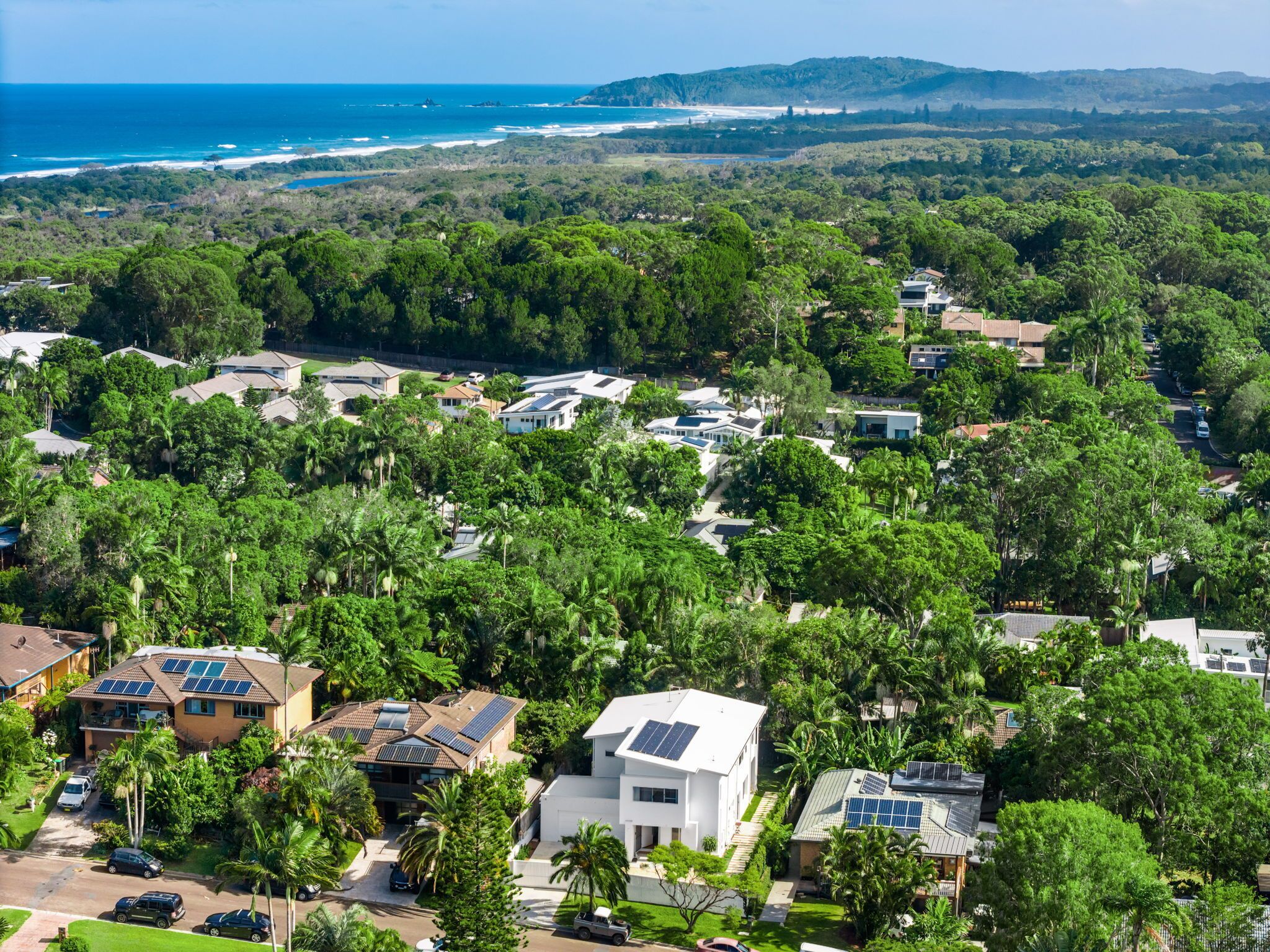 Un quartier résidentiel où les maisons sont entourées d’une végétation luxuriante et offre une vue sur l’océan.