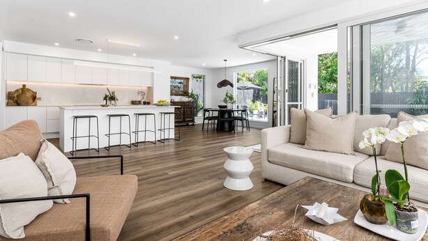 Un salon moderne comprenant un canapé, une table basse et un coin repas avec une table et des chaises.
