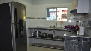 A kitchen with a refrigerator, sink, and various cooking utensils. - Finca el Paraiso Casa Loma, Tena (Cundinamarca)