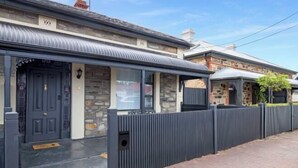 A residential property with a stone facade, a metal roof, and a gated entrance. - Beach & Pines Large 3Br House Glenelg Wifi BBQ (Glenelg South)