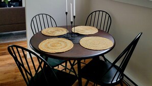 A dining area with a round table, four chairs, and a chandelier. - Rural Town Oasis in Bonavista  (Bonavista)