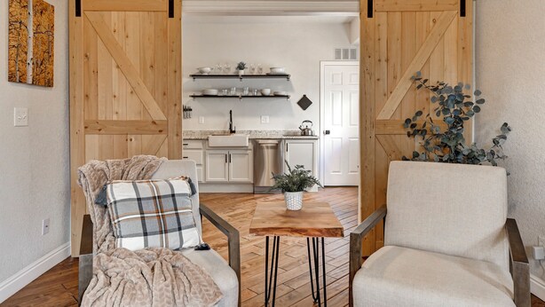 Ein gemütliches Wohnzimmer mit Kamin, einem Esstisch und einer Küche im Hintergrund.