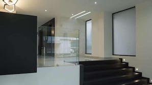 A modern staircase with glass railings and recessed lighting. - Mc Suites Reforma (Mexico City)