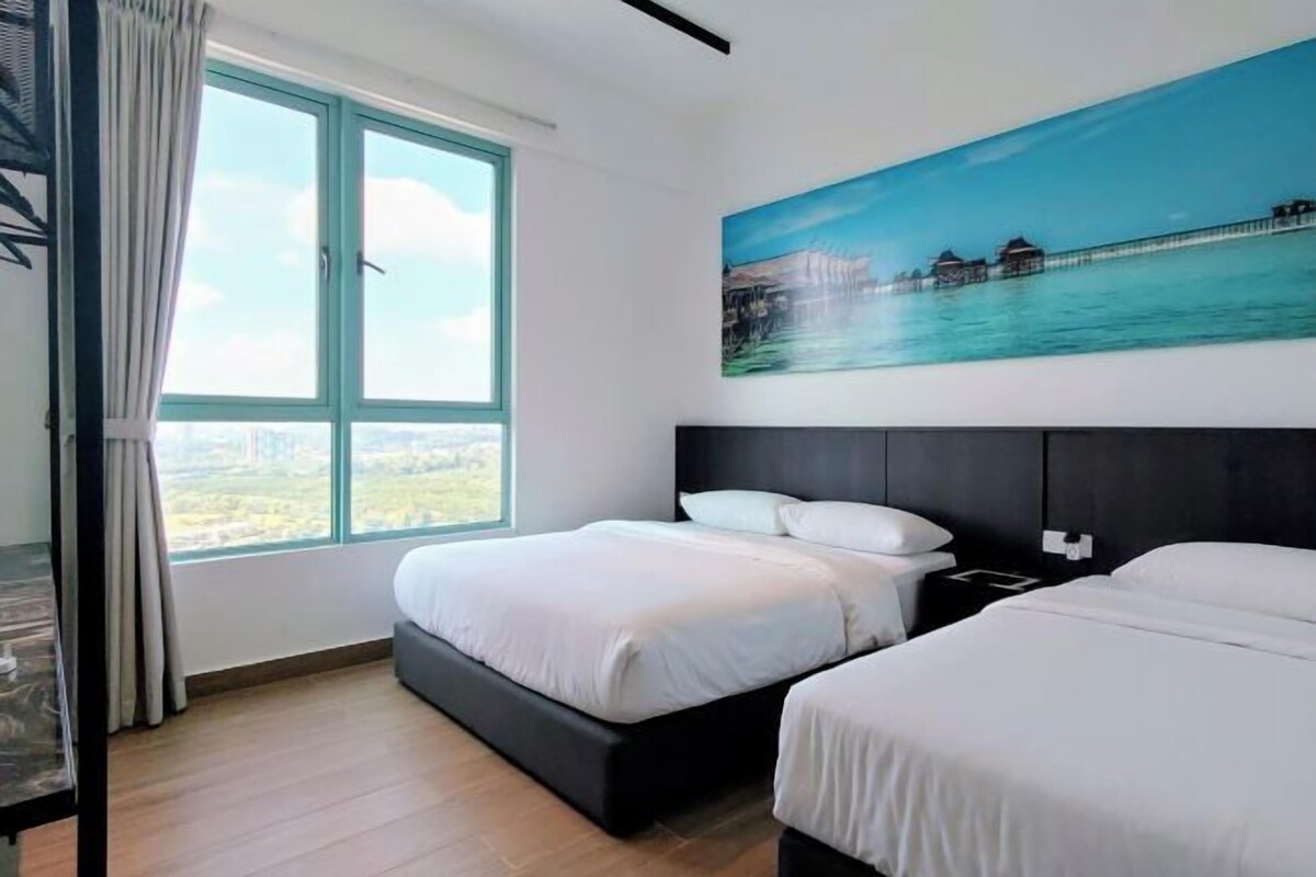 Une chambre d’hôtel avec deux lits, une grande fenêtre et un tableau représentant un paysage côtier.