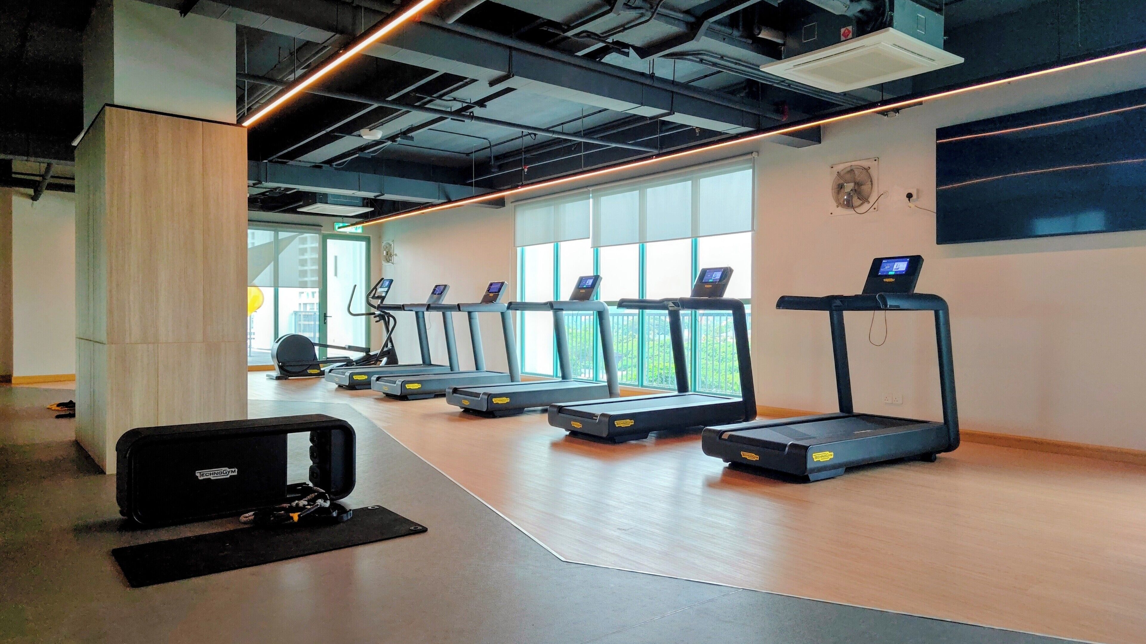 Une salle de sport équipée de tapis de course, d’un rameur et d’un vélo d’appartement.