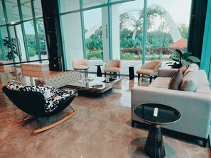A modern lobby with a sofa, chairs, a coffee table, and a rocking chair. - La.mer Butik Hotel (Kota Kinabalu)