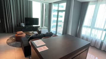 En moderne stue med en stor ø, et fladskærms-tv og en sofa.