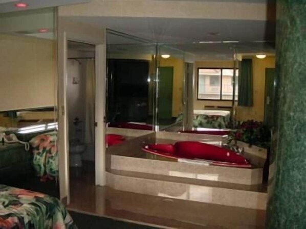 A room with a large mirror, a red sofa, and a small table. - Miami Princess Hotel (Miami)