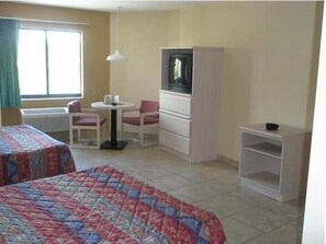 A hotel room with two beds, a TV, a desk, and a chair. - Miami Princess Hotel (Miami)
