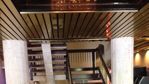 A staircase with wooden steps and a metal railing, leading to an upper level. - Miami Princess Hotel (Miami)