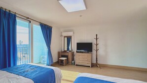 Habitación de hotel con dos camas, un escritorio, un televisor y un armario.