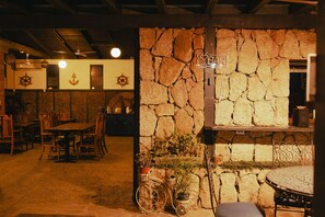 A rustic interior with stone walls, wooden furniture, and a bar area. - Hotel Villa Vitta (Bahia de los Angeles)