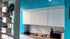 Una cocina moderna con armarios color turquesa, encimera de madera y horno empotrado.