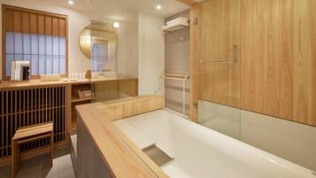 A modern bathroom with a wooden vanity, a glass shower enclosure, and a large mirror.