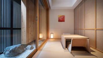 A traditional Japanese room with tatami flooring, a low wooden table, sliding shoji doors, and two wall-mounted lanterns.