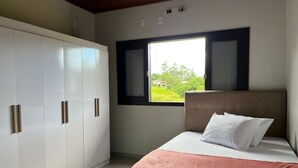 Une chambre à coucher avec un lit, une fenêtre et une armoire.