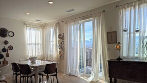 A dining area with a table and chairs, large windows with sheer curtains, a wall-mounted plate collection, and a view of a cityscape. - Views, Views, Views.Beautiful 2800 sqft 30 mins to Tahoe large backyard. (Reno)