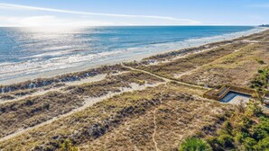 A beach with a wooden structure, sandy dunes, and a clear view of the ocean. - Experience luxury at 5 Periwinkle Lane, with private pool and a 5-minute walk to the beach! (Hilton Head Island)