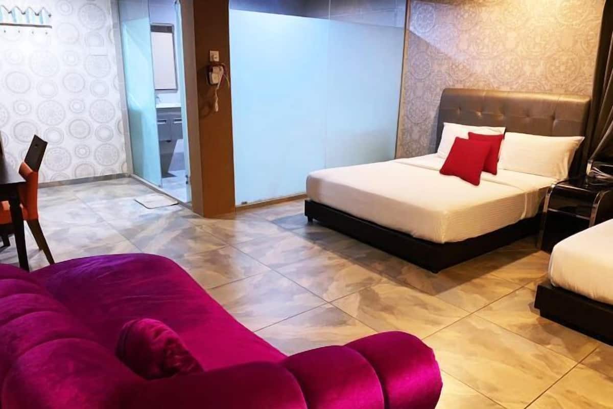 A hotel room with a bed, a chair, and a large window.