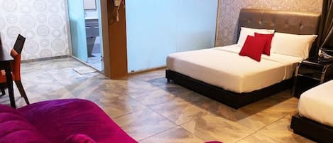 A hotel room with a bed, a chair, and a large window.