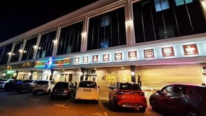 Un hotel con varios espacios de estacionamiento y una fila de iconos iluminados que muestran diferentes servicios.