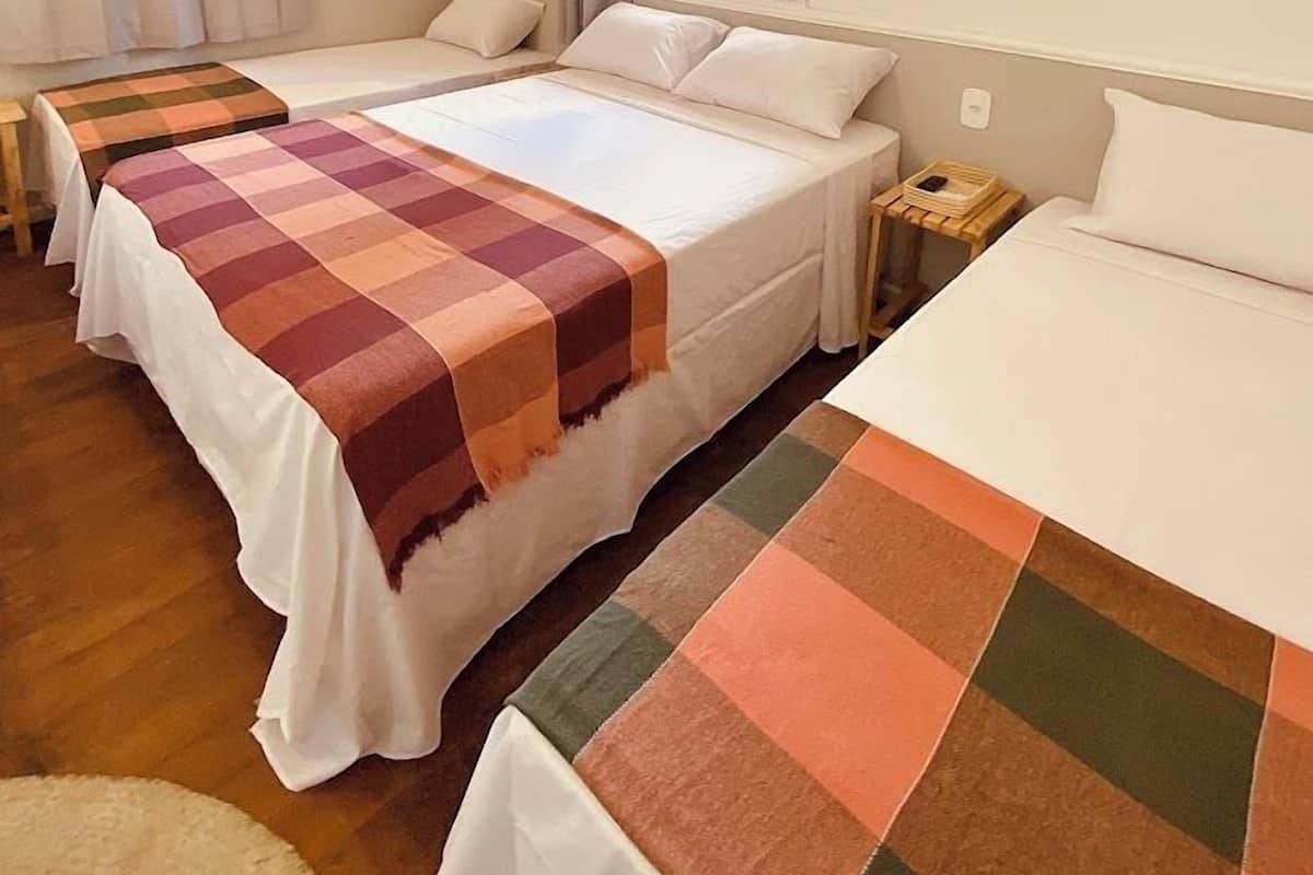 Ein Hotelzimmer mit zwei Betten, einem Fenster und Blick nach außen.
