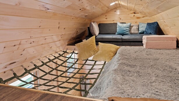 A cozy cabin interior with a wooden ceiling, a sofa with cushions, and a hammock. - Rainbow Ranch: Family Friendly 4 Bedroom in Lovely Williamstown, 5 min to ARK! (Williamstown)