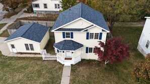 A two-story house with a covered porch and a small attached garage. - Lakeside Horizon - minutes to Lake Michigan Pere Marquette Beach & Muskegon Lake (Muskegon)