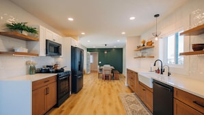 Una cocina moderna con armarios de madera, una isla central y electrodomésticos integrados.